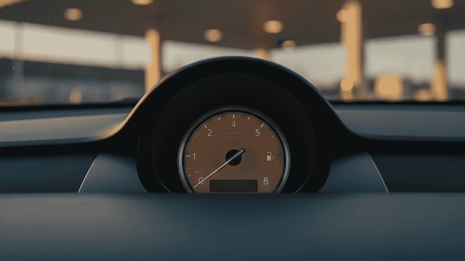 Instrument tabla evropskog automobila sa pokazivačem goriva između polovine i četvrtine, toplo popodnevno svjetlo obasjava unutrašnjost vozila