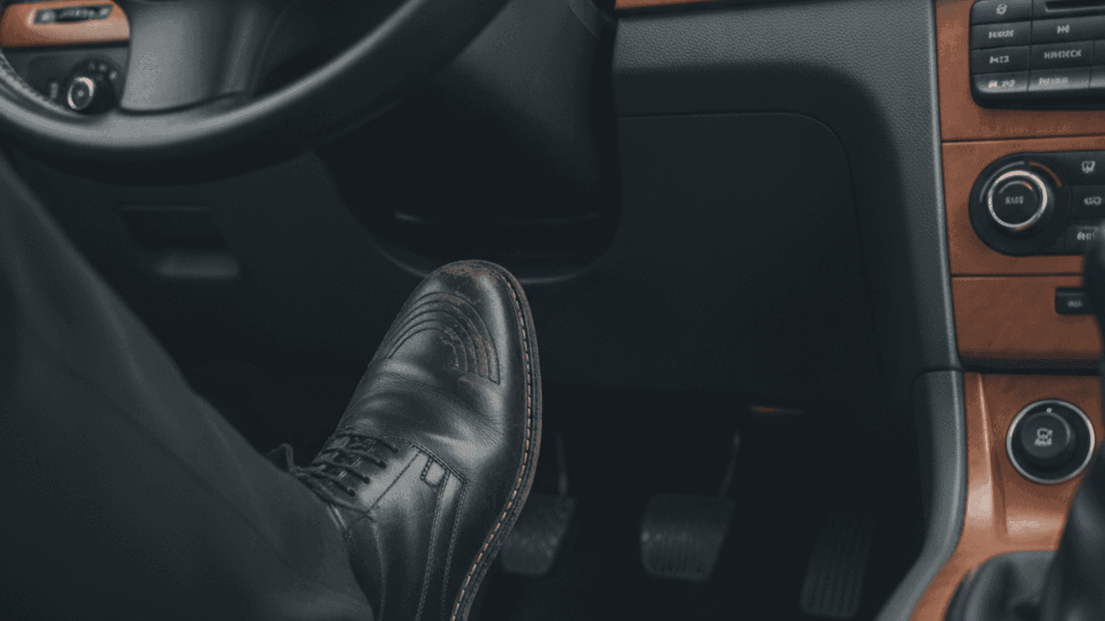 Krupni kadar vozačeve lijeve noge iznad pedale kvačila u automobilu sa ručnim mjenjačem
